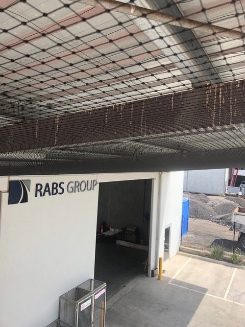 Bird netting under the entry canopy of a commercial building