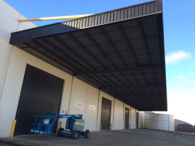 Bird netting under a warehouse awning above the roller doors
